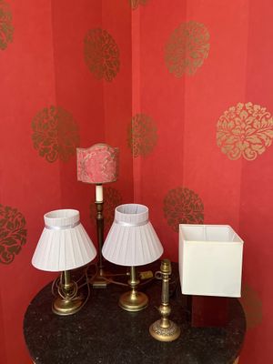trois lampes posées sur une petite table dans un coin de la pièce