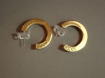 une paire de boucles d'oreilles créoles plaquées or, ornées du mot « frecc »