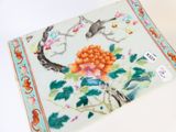 une photo d'une assiette décorée d'un oiseau et de fleurs