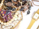a basket full of assorted jewelry on a table
