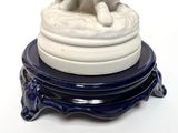 a statue of a woman sitting on a stack of plates