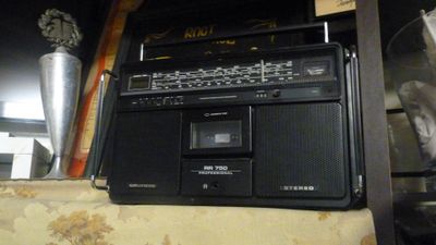 une radio posée sur une étagère à côté d'un vase