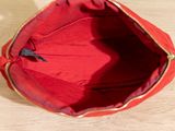 a red purse sitting on a table with a black handle