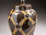 a brown and yellow vase with a light on it