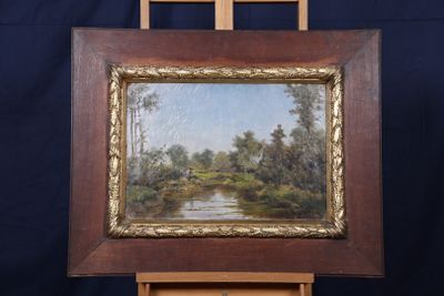 une peinture à l'huile représentant une rivière et des arbres, dans un cadre en bois