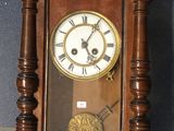 a wooden clock hanging on the wall on a tiled floor