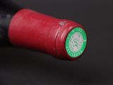 a close up of a red wine bottle with a green label