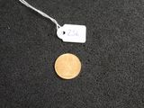 a close up of a coin on a black surface with a price tag