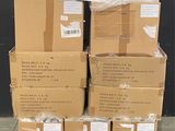 des cartons empilés sur une palette devant un mur noir