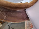 a mannequin in a room with a brown coat on