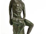 statue représentant un homme assis sur un rocher, les jambes croisées
