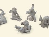 five figurines of angels sitting on the ground