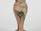 un vase rose orné d'un motif vert et blanc