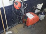a red and black machine sitting next to a blue and white wall