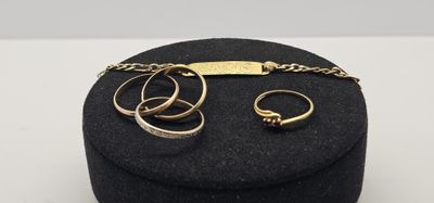 deux bagues en or et une chaîne posées sur un coffret noir