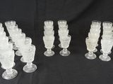 six verres à pied en verre transparent sont alignés sur un fond noir
