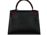 a black leather handbag with red handles on a white background