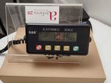 an electronic scale sitting on top of a cardboard box