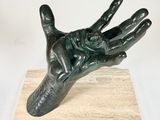 statue of a hand holding a flower on a marble base