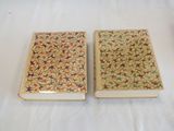 two books sitting on top of a white table next to each other