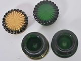 three green glass vases and a gold flower on a table