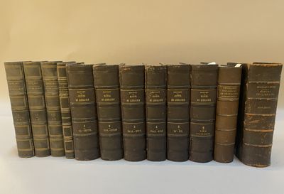 plusieurs vieux livres alignés sur une surface blanche
