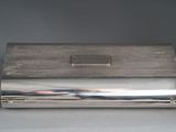 an antique silver cigarette case on a grey background