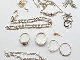 Plusieurs types de bijoux sont disposés sur une surface blanche