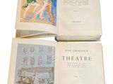 three books are open on a white surface with a drawing of a woman
