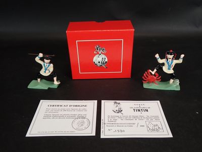 deux figurines représentant des hommes en uniforme militaire, accompagnées d'une boîte rouge