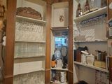 a corner of a kitchen with a lot of dishes on the shelves
