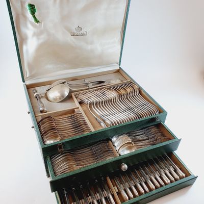 a green box with silverware in it on a white surface