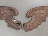 two wooden angel wings on a white wall