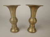 two gold vases sitting next to each other on a table