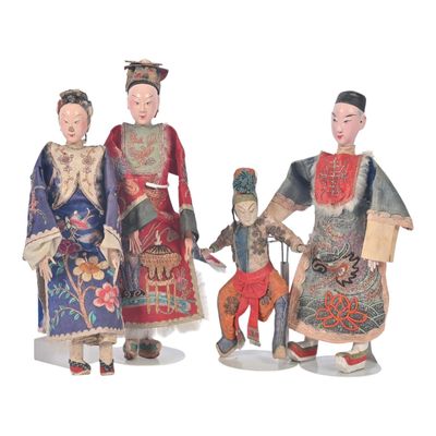 three figurines of asian people are standing next to each other