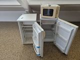 a small refrigerator with a microwave on top of it
