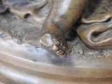 a bronze statue of a person laying on a pillow