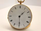 une montre de poche en or avec des chiffres romains sur le cadran