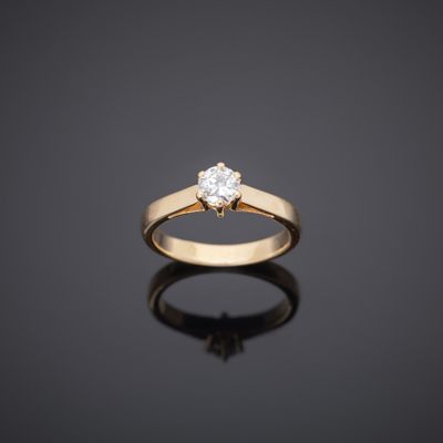 a single stone diamond ring on a black surface