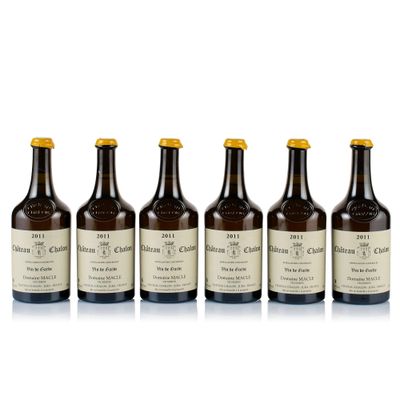 six bottles of wine are lined up on a white surface