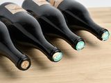 quatre bouteilles de vin sont alignées sur une table en bois