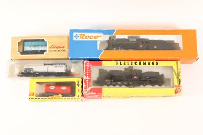 three boxed trains sitting next to each other on a white surface