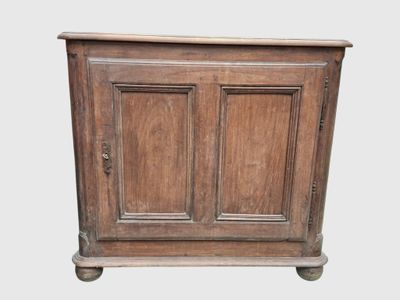 an old wooden cabinet with two doors and a drawer underneath