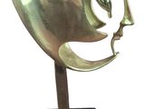 brass sculpture of a man ' s face on a black base