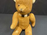 a yellow teddy bear with a black collar on it