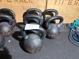 cinq kettlebells posés sur une table, avec une étiquette de prix