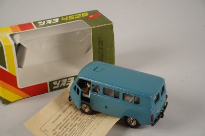 un petit bus en jouet posé devant une boîte