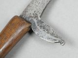 a knife with a wooden handle on a white surface