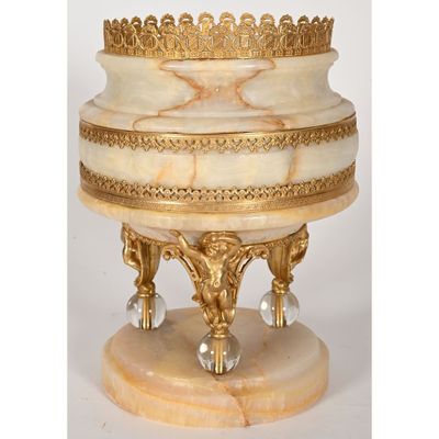 un socle en marbre blanc orné de moulures dorées et surmonté d'une couronne