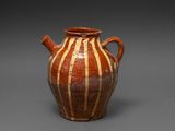 vase marron et blanc, orné de rayures sur un fond gris